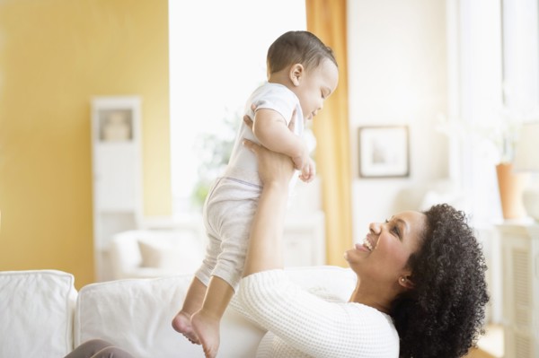 Mixed race mother playing with baby on sofa