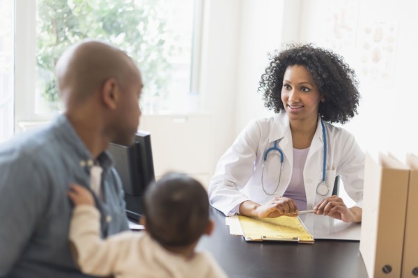 Father with baby talking to doctor