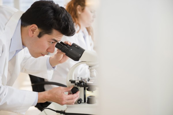 Scientist using microscope in lab