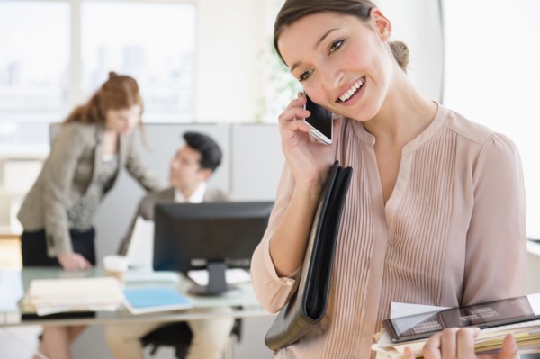 Businesswoman talking on cell phone in office