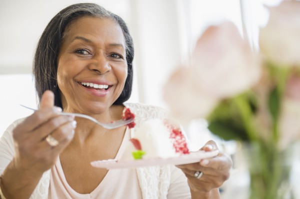 Mixed race woman sharing cake