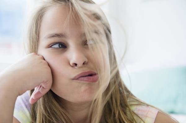Caucasian girl blowing hair from her face
