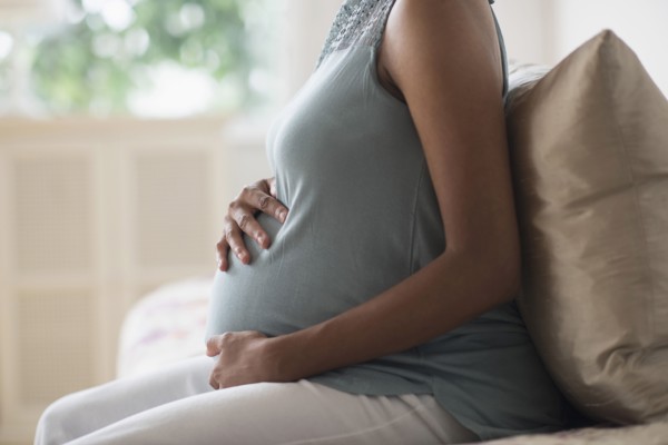 Pregnant African American mother holding her stomach