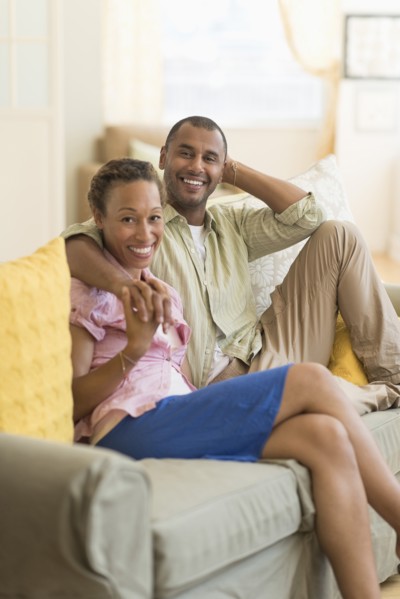 Couple smiling on sofa in living room