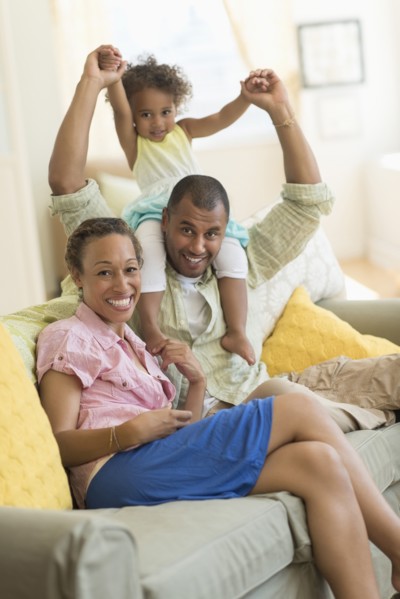 Family smiling on sofa in living room
