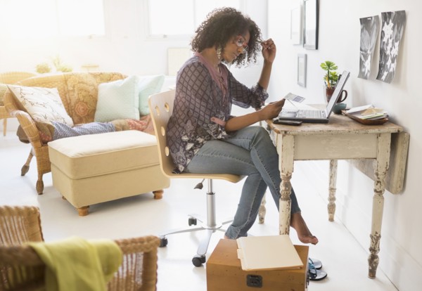 Mixed race woman using laptop in living room