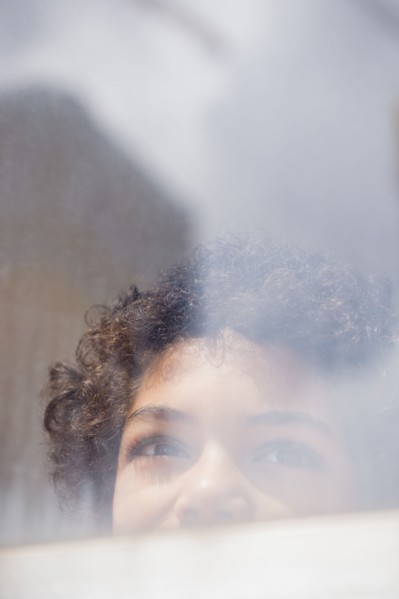 Mixed race boy looking out window