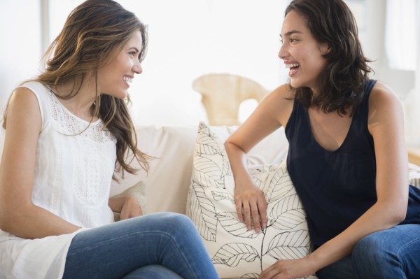 Hispanic women talking on sofa