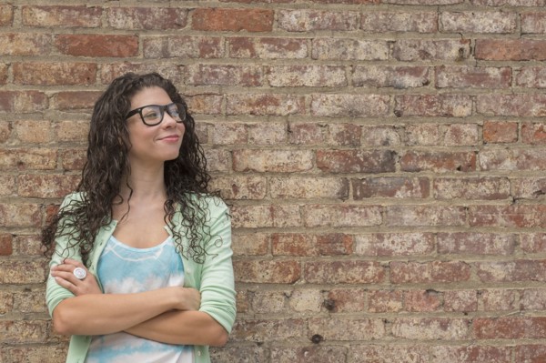 Pensive mixed race woman standing with arms crossed