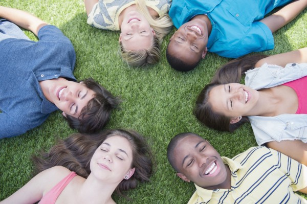 High angle view of teenagers laying on grass lawn