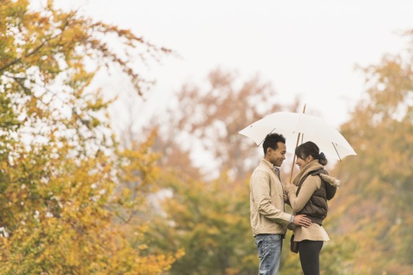 Couple standing with umbrella in park