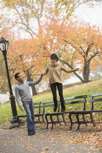 Couple playing on park bench