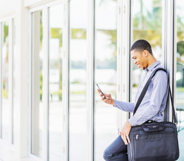 Black businessman using cell phone outdoors