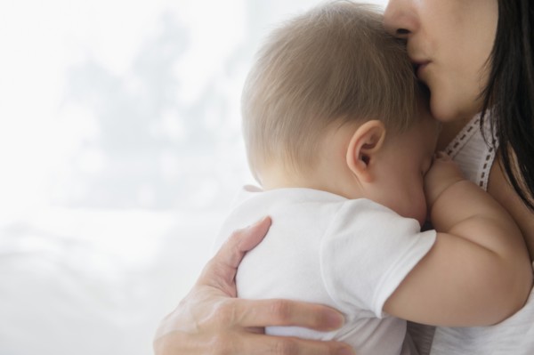 Close up of mixed race mother kissing baby on forehead
