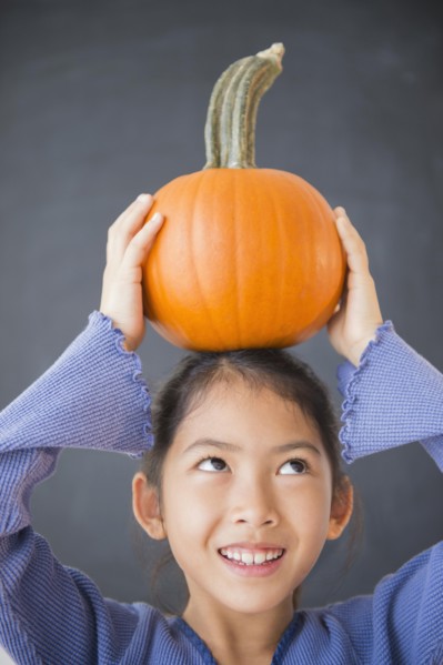 Vietnamese girl balancing pumpkin on head