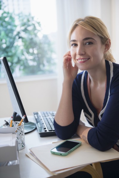 Caucasian businesswoman smiling at desk