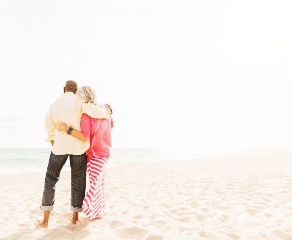 Older couple hugging on beach