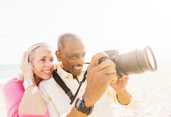 Older couple photographing on beach