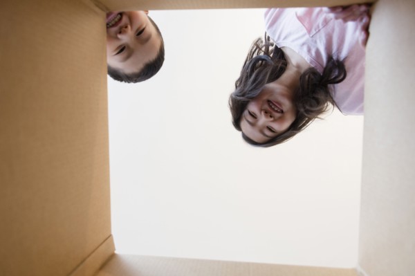 Low angle view of Asian brother and sister opening box