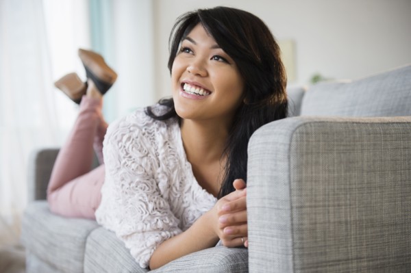 Pacific Islander woman laying on sofa