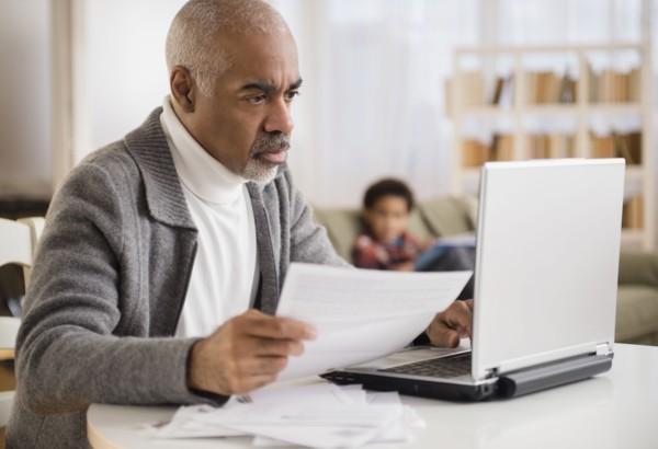 Mixed race man paying bills on laptop