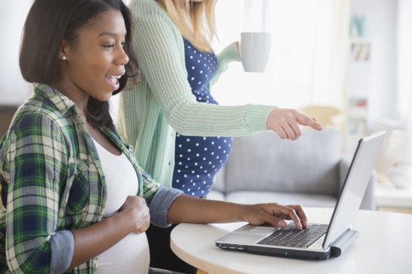 Pregnant women using laptop at table