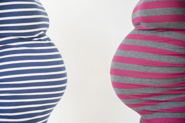 Close up midsection profiles of stomachs of pregnant women
