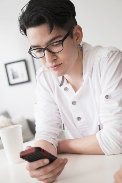 Mixed race man texting on cell phone