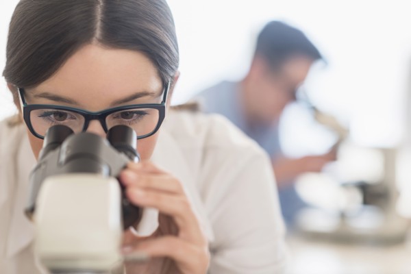 Scientist using microscope in research laboratory