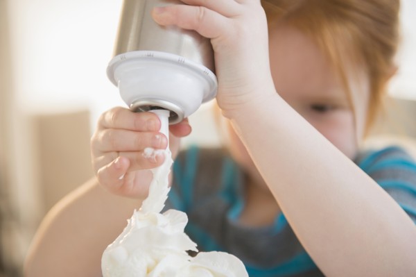 Caucasian girl spraying whipped cream
