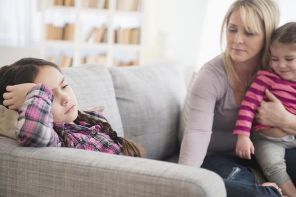 Caucasian mother comforting upset daughter on sofa
