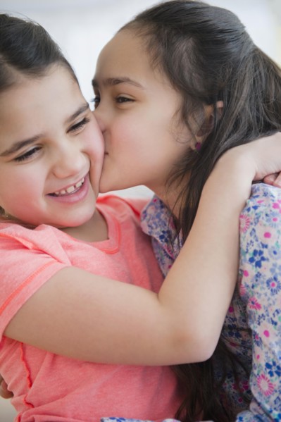 Close up of Caucasian sisters kissing