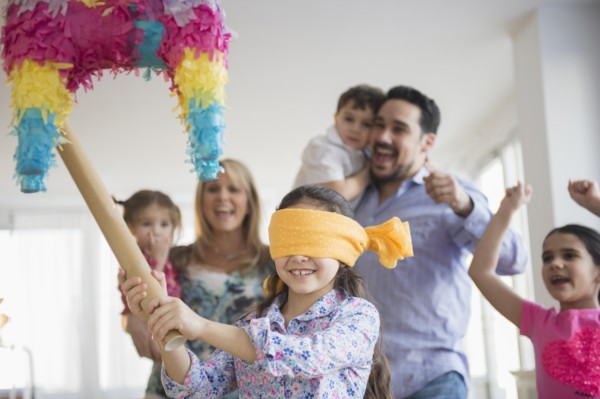Caucasian girl hitting pinata at birthday party