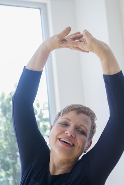 Caucasian woman stretching near window