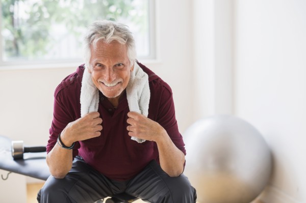 Smiling older Caucasian man resting in gym