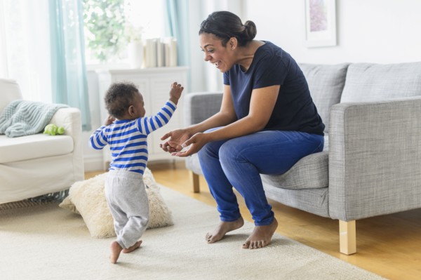Mixed race mother playing with baby son in living room