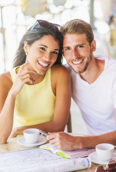 Hispanic couple reading map at cafe