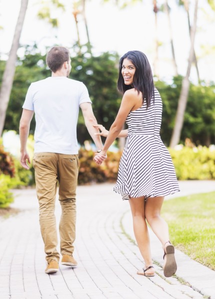 Smiling Hispanic couple walking in park