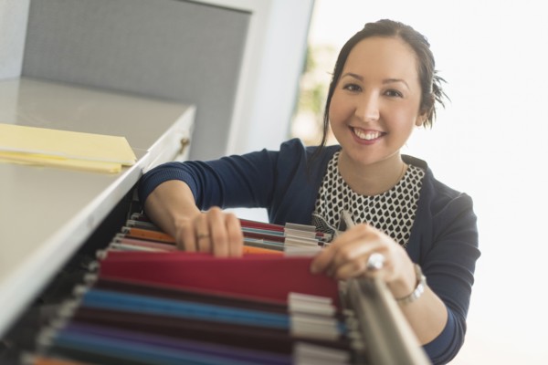 Mixed race businesswoman choosing files in office