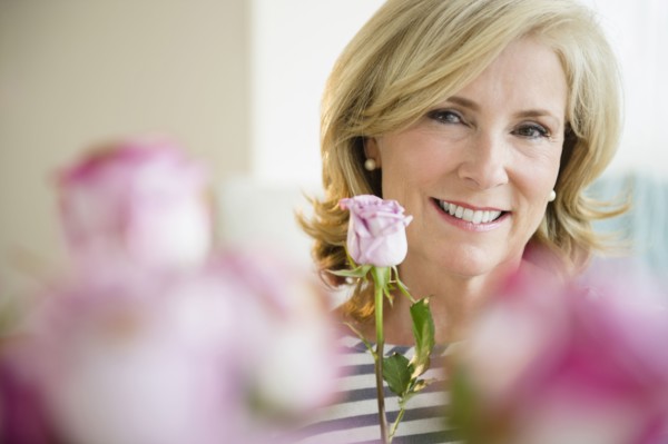 Caucasian woman holding pink rose
