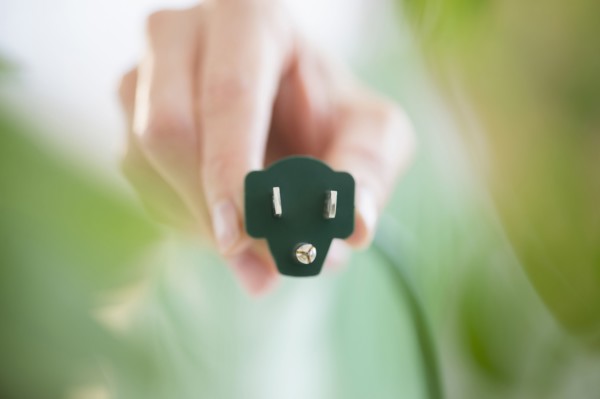 Mixed race woman holding electrical plug