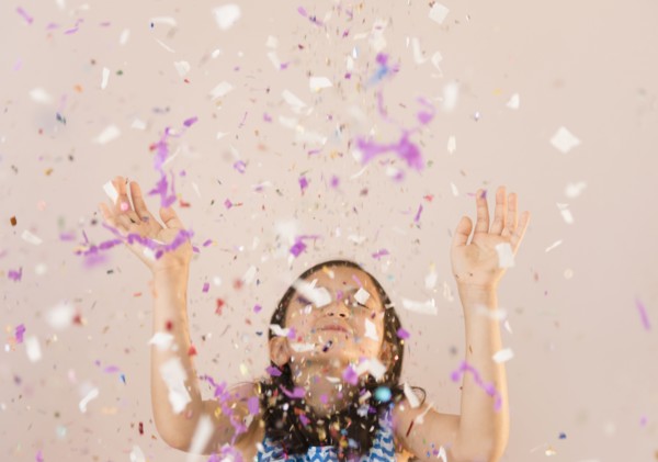 Girl tossing confetti in air