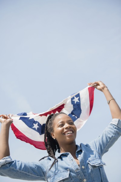 Black woman carrying American flag banner