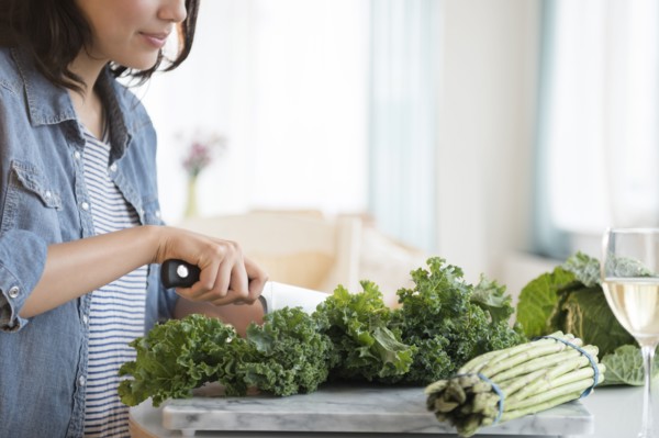 Hispanic woman chopping salad greens
