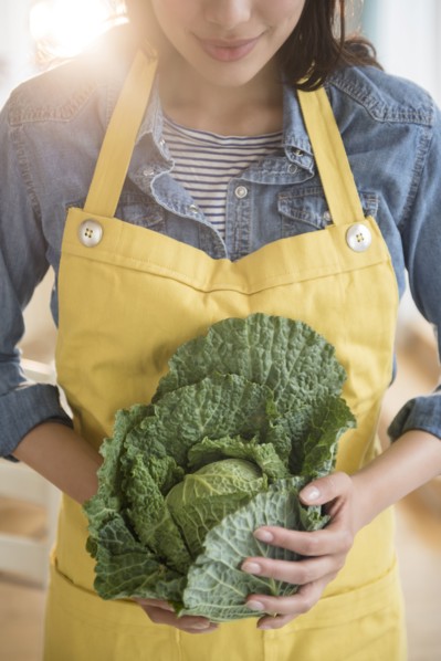 Hispanic woman holding head of lettuce