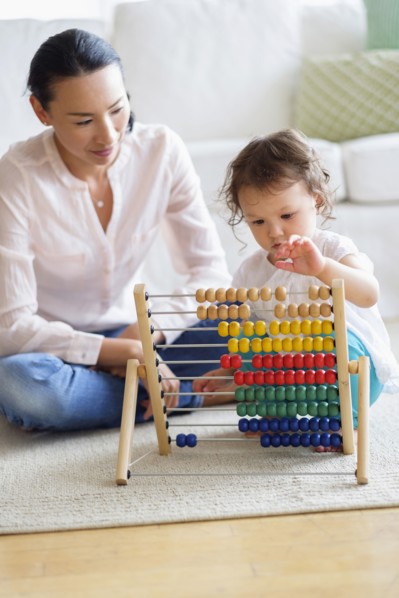 Mother and baby girl playing with abacus