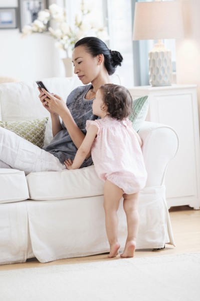 Mother and baby daughter using cell phone