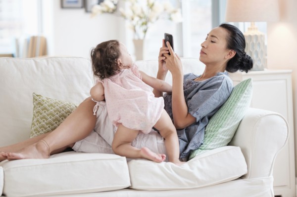 Mother photographing baby daughter