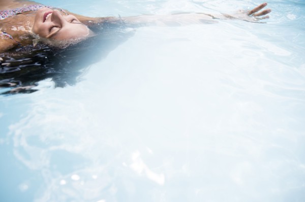 Caucasian woman floating in swimming pool