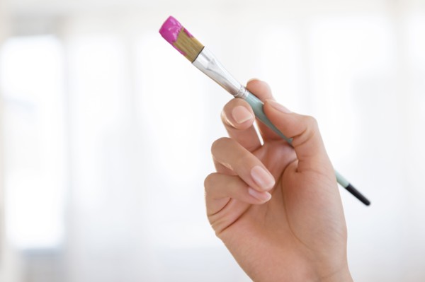 Hispanic woman holding paintbrush